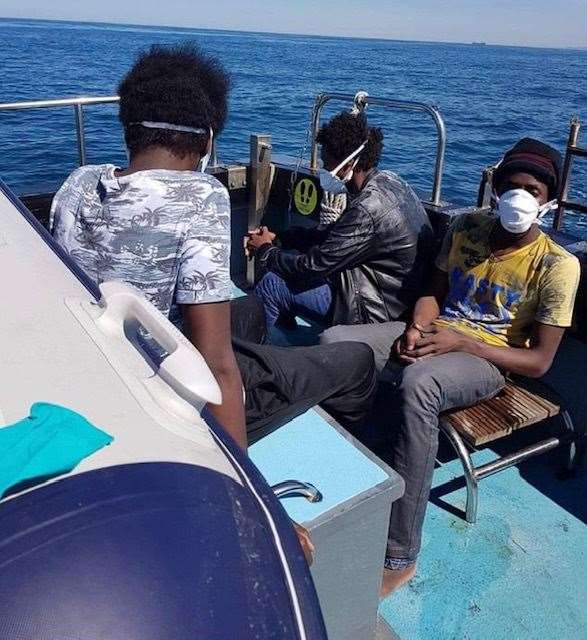 The three rescued migrants on the pilot boat