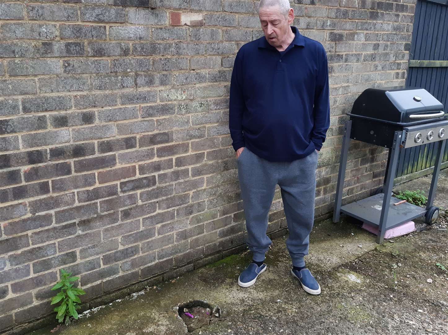 Former bin man Ron Garrott next to the small void which has appeared in his garden