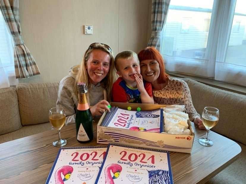Artist Bryony Sadler, Digby Donnelly and mum Lisa Donnelly celebrate the first batch of calendars