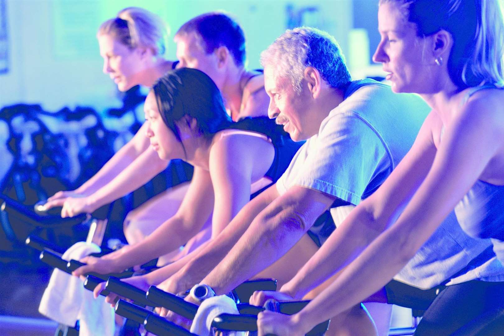 Group of people on exercise bikes in a health club