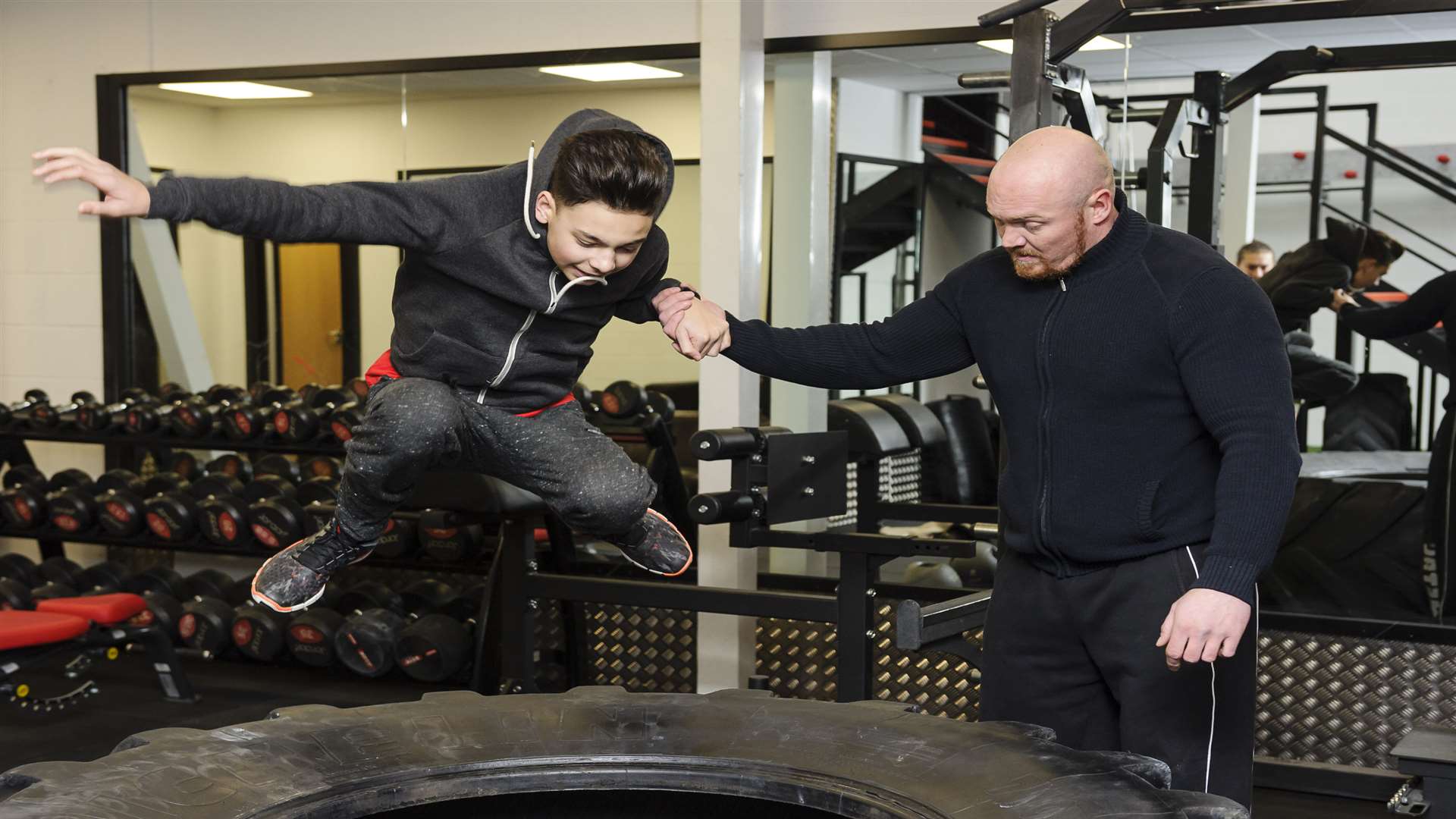 Zach Knight, 13, is shown the tyre leap by Britain's strongest man competitor Jay Hughes.