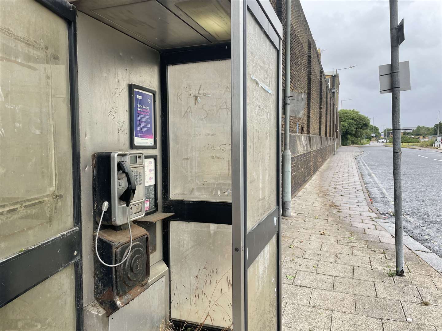The BT payphone in Blue Town has weathered windows and is covered in graffiti