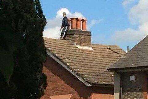 The man is seen standing on the roof during the Tonbridge stand-off