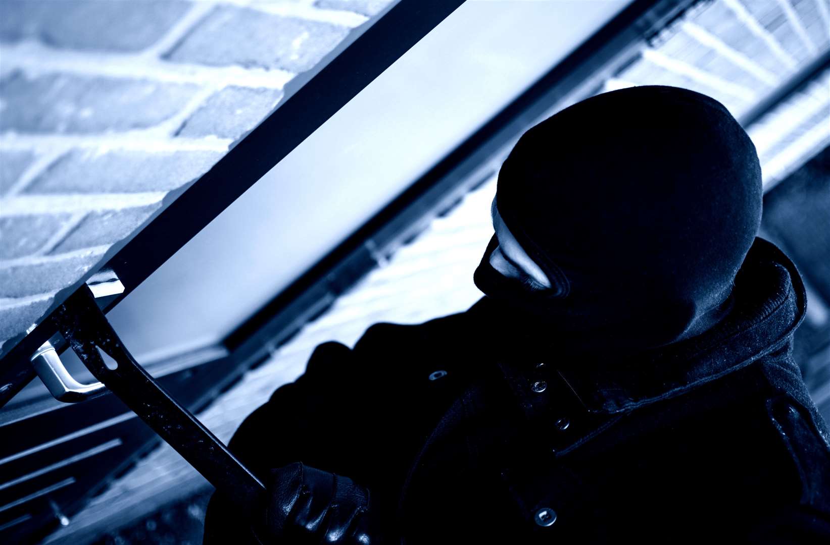 A burglar breaking into a home. Stock picture
