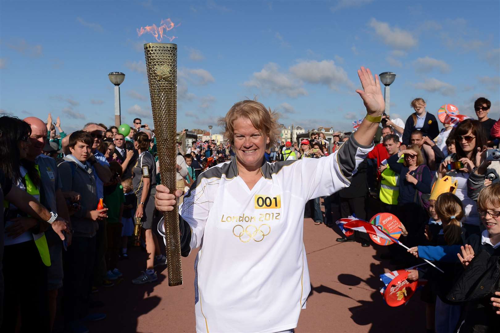 Torchbearer Katherine Batts holds the Olympic Flame in Deal at the beginning of Day 62 of the London 2012 Olympic Torch Relay – July 19, 2012. Picture: LOCOG