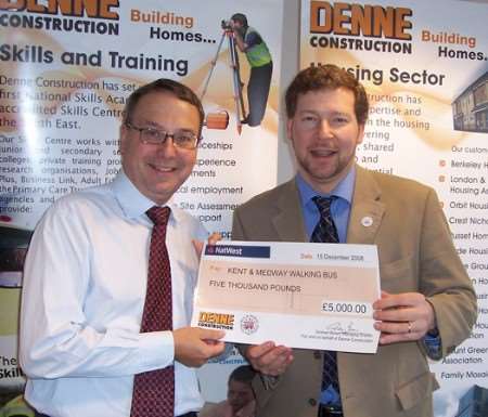 Graham Brown, managing director of Denne Construction, presents a cheque following a golf day at Boughton Golf Club, to Simon Dolby of the walk to school charity