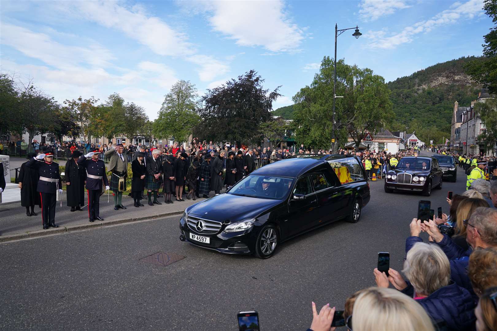 Members of the military salute the hearse carrying the coffin of the Queen in Ballater. Andrew Milligan/PA