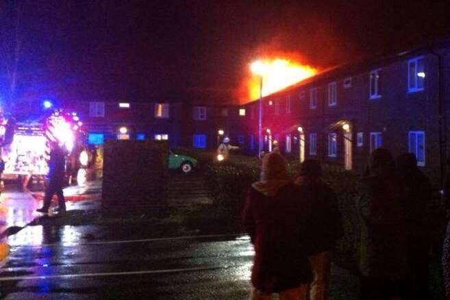 Flames can be seen coming through a roof at student accommodation. Picture: @Kent_999s