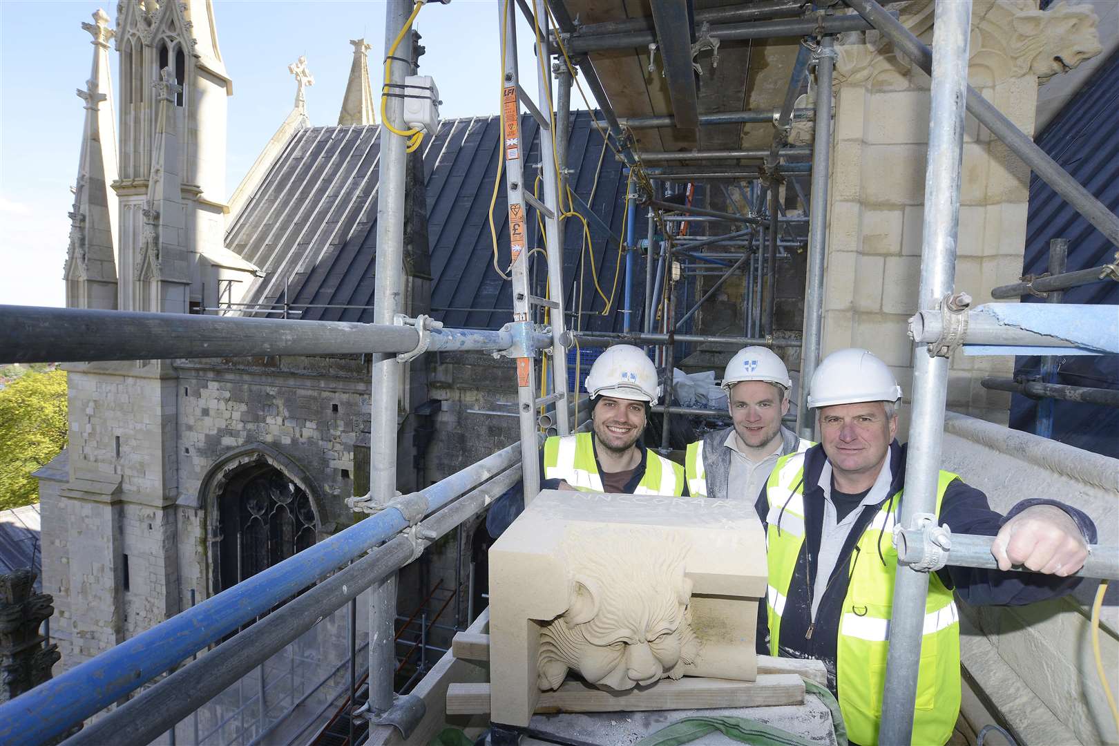 The first gargoyle put into place by Ian Gartside, with stonemasons Tony Murphy and Neil Bishop. Picture: Paul Amos.
