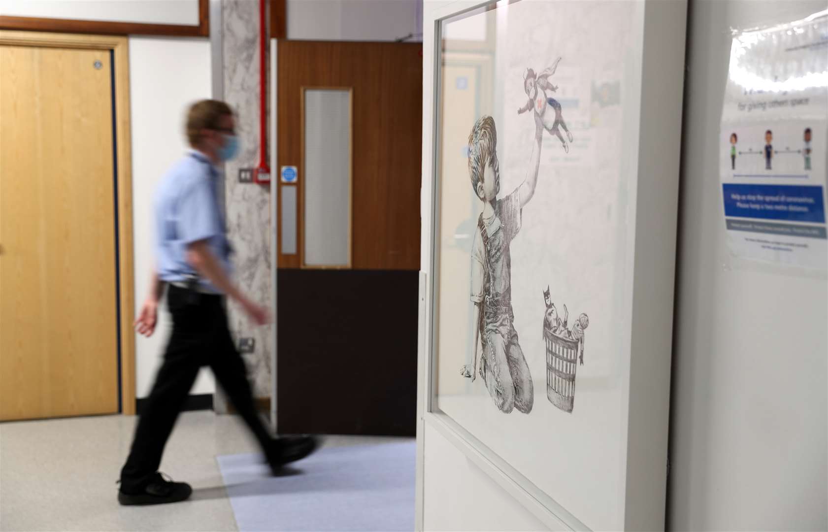 A person walks past the artwork which has gone on display in a corridor at the hospital (Andrew Matthews/PA)