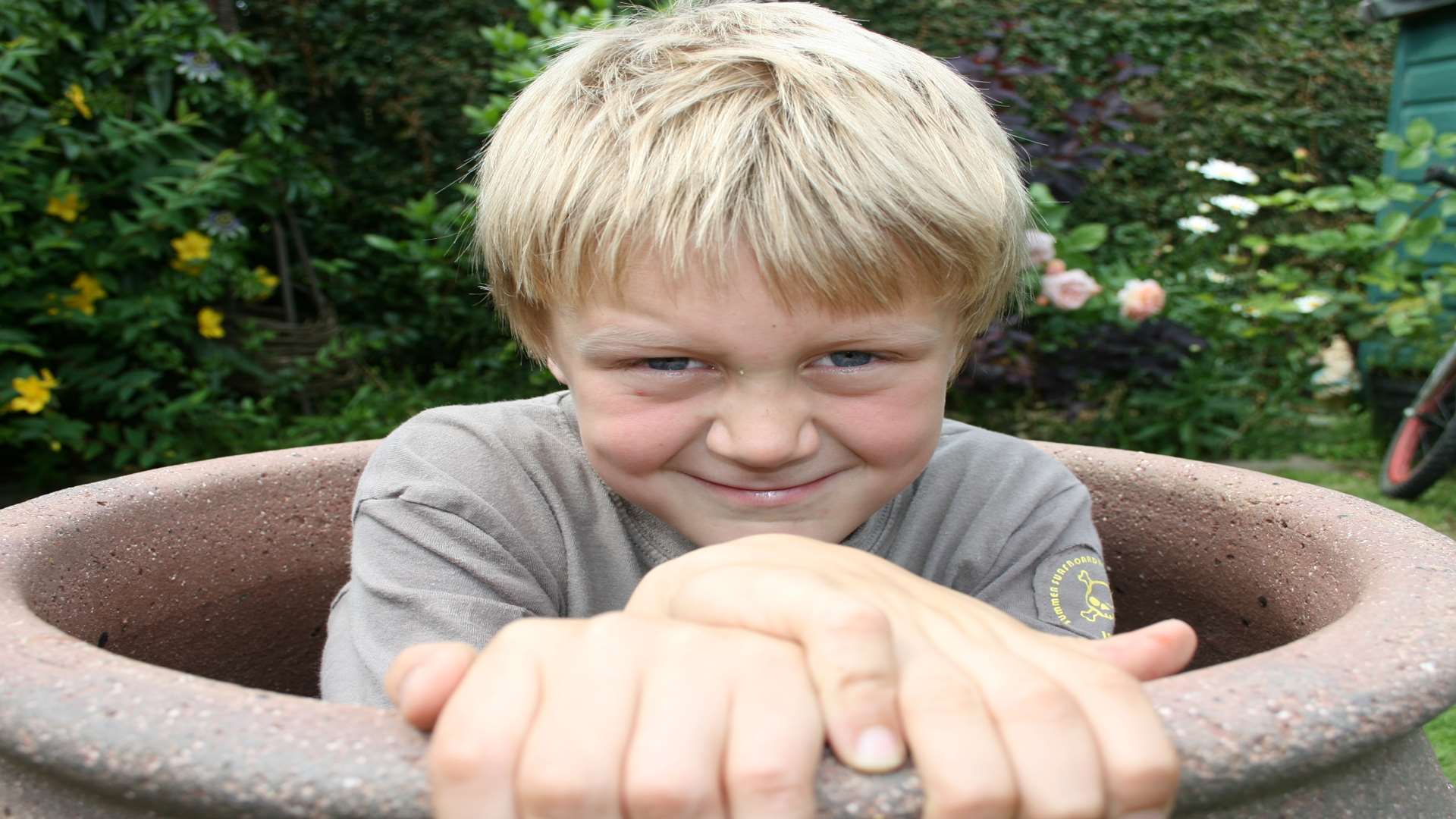 Ben, aged six, hiding in a plant pot