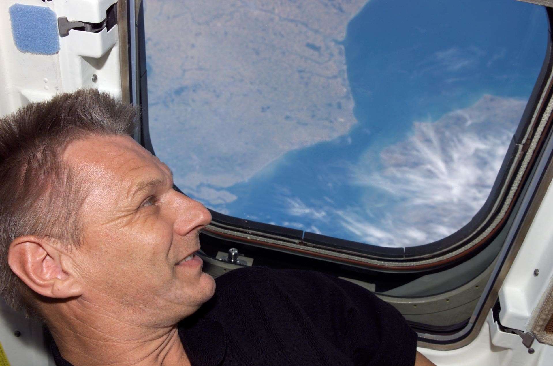 Piers Sellers peers down at the Earth as he orbits in during one of his three missions. Picture: Nasa