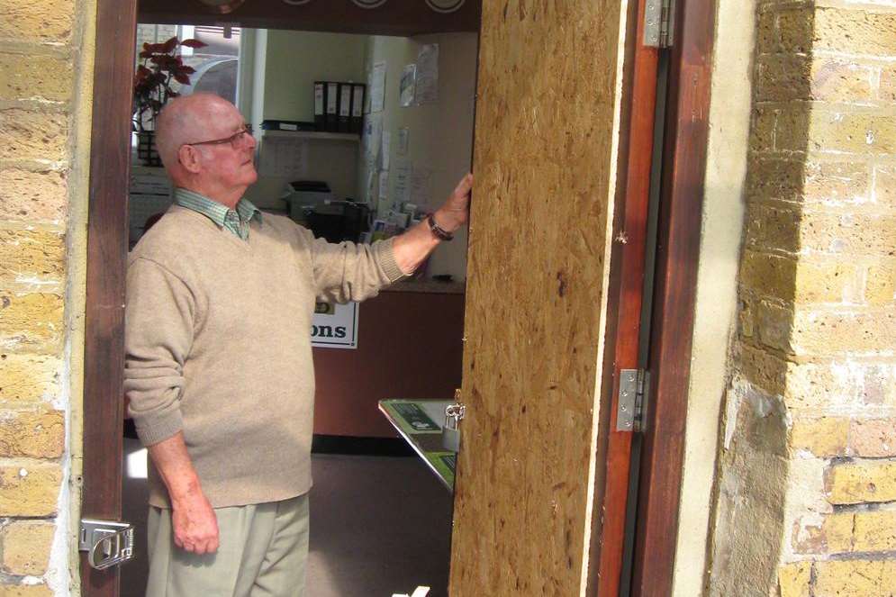 Stan Rayfield surveys the already boarded door damaged in the break-in