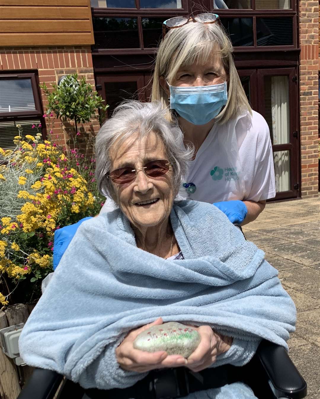 Jean from the Heart of Kent Hospice with her carer and a pebble she has decorated