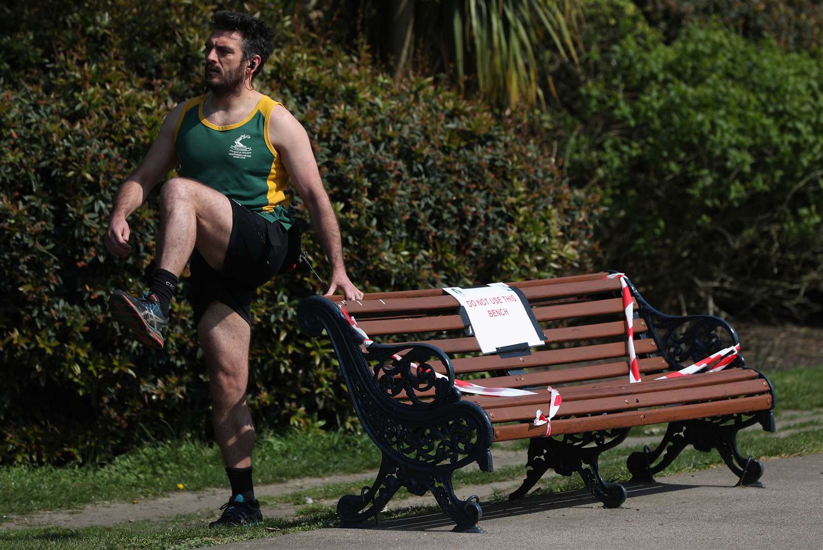 A man exercises next to a taped-off bench (Jonathan Brady/PA)