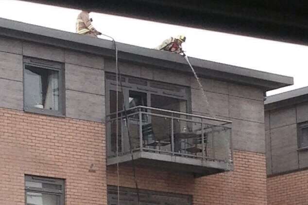 Firefighters scale the building to tackle a fire on the fourth floor. Picture by Tony Coomes