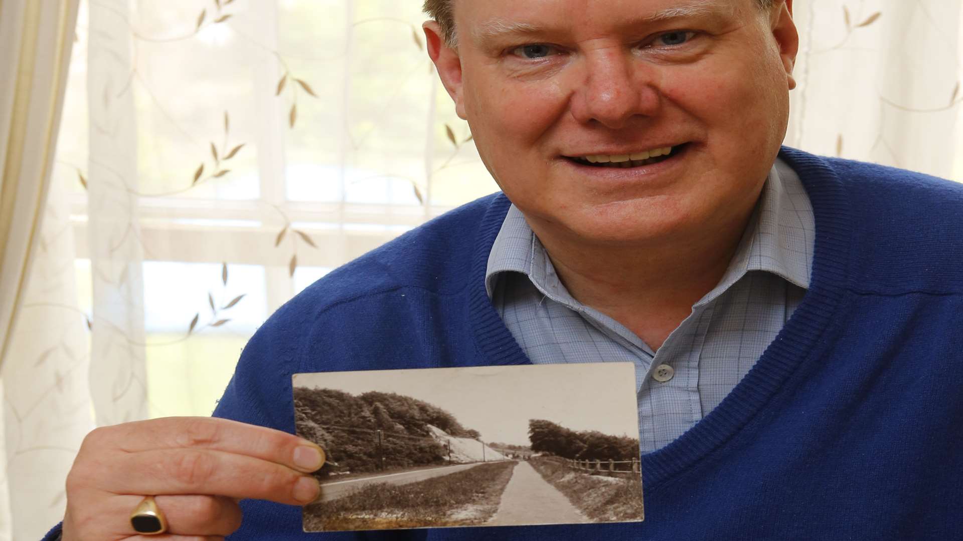 Colin Mann holding up a post card he bought five years ago on eBay that was sent by his mother. Picture: Andy Jones