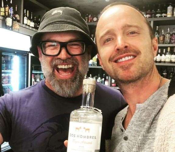 Aaron Paul poses with The Offy manager Ross Bell and a bottle of his mezcal, Dos Hombres. Picture: Ross Bell