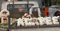 A truck bearing floral tributes to the young woman