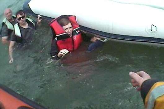 Rescuers help after the boat capsizes