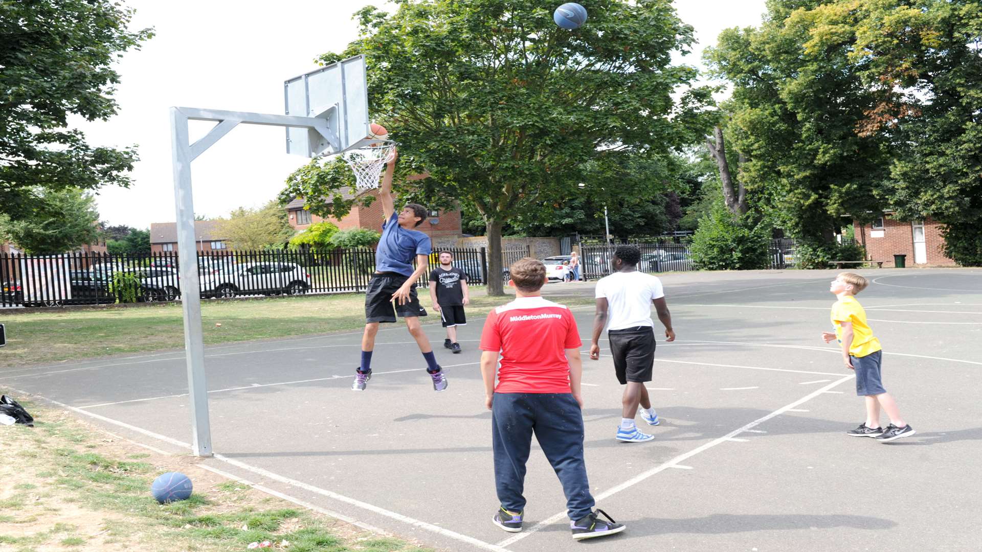 A group of boys enjoy playing basketball on the courts at Woodlands Park, Gravesend