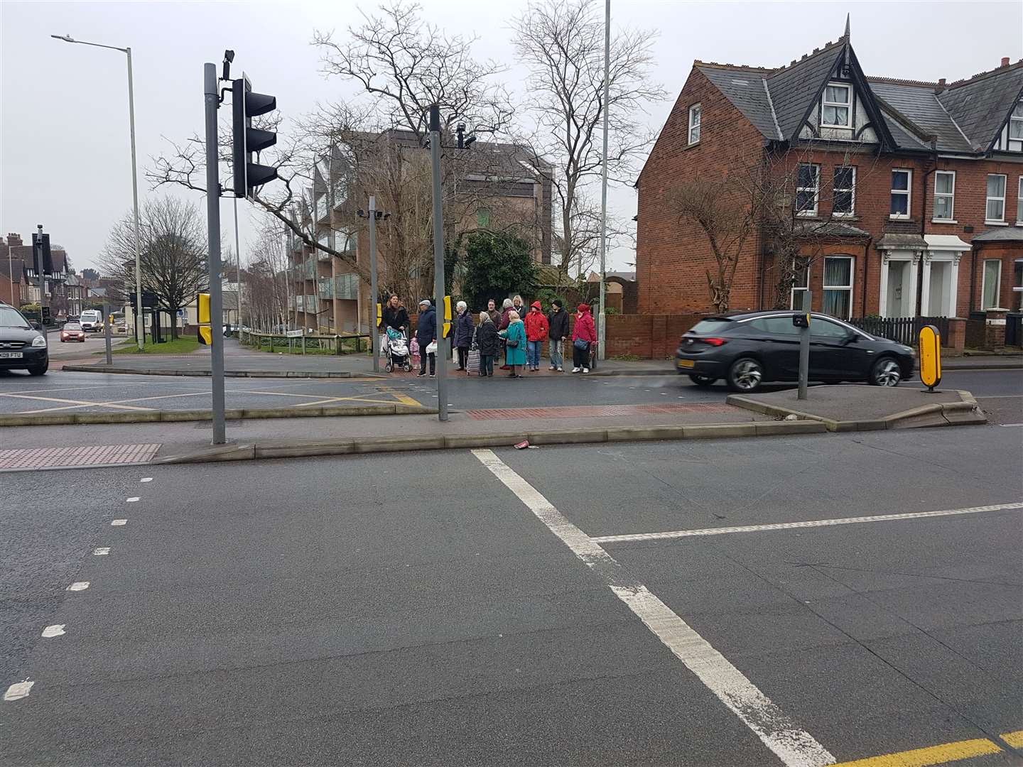 A gaggle of pedestrians are waiting to cross, with no ability to halt the traffic (27430612)