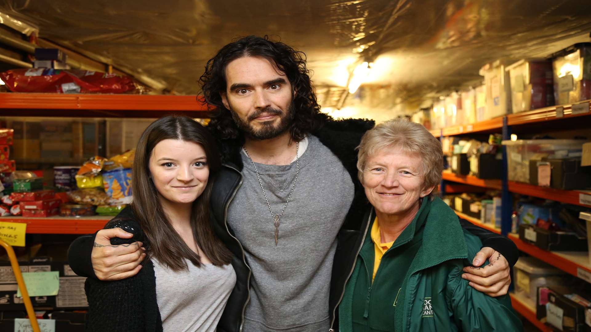 Russell Brand with Canterbury Food Bank volunteers Chrissie and Poppy Barr