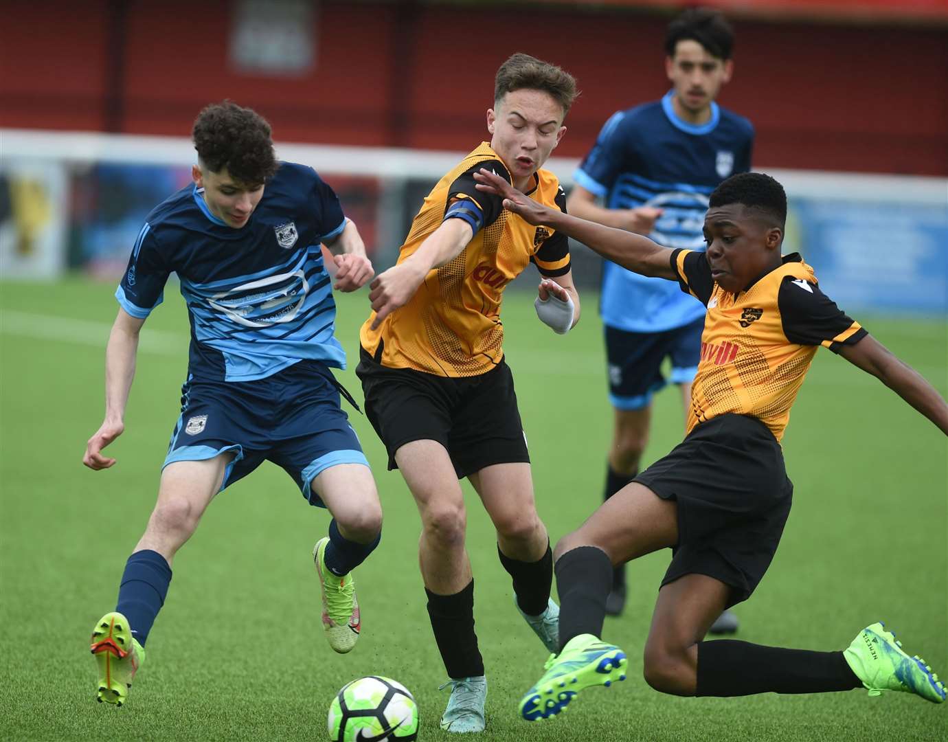 Maidstone United under-14s slide in against Rochester City under-14s (blue). Picture: PSP Images