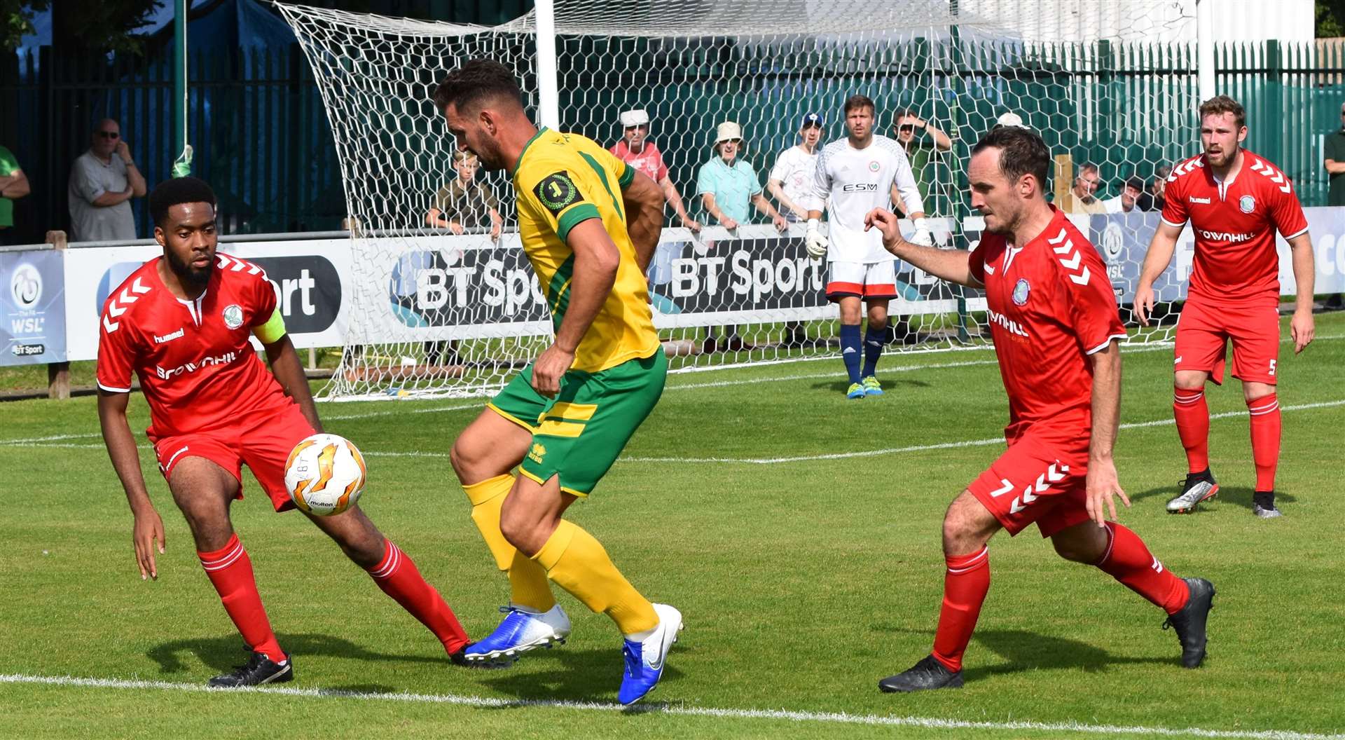 Ashford United's Jay May shields the ball from two Beckenham defenders during Saturday's FA Cup tie. Picture: Alan Coomes