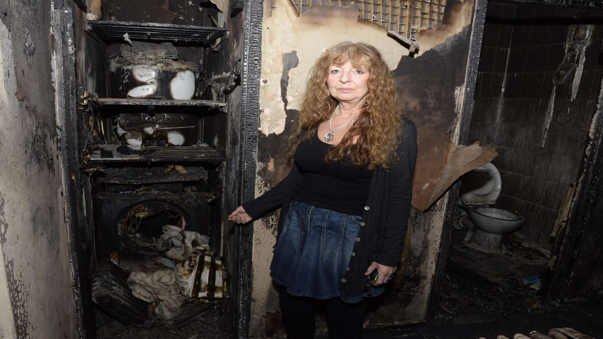 Veronica Tinkler shows the damage caused by the fire