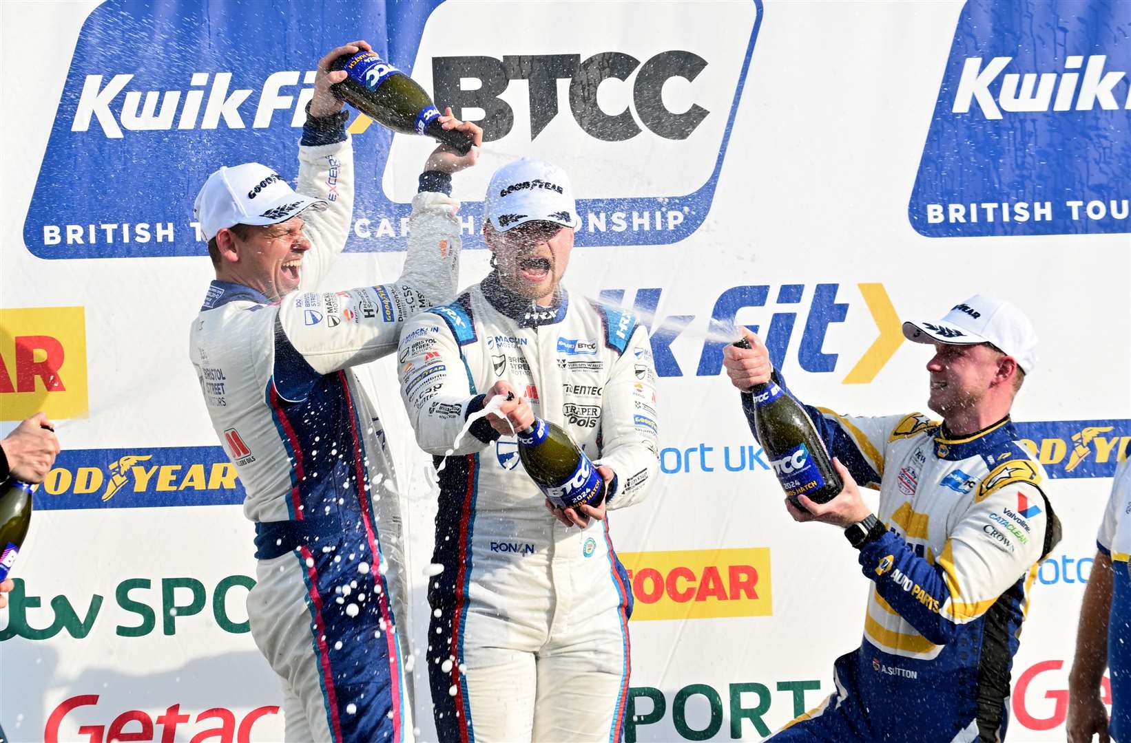 Ronan Pearson, centre, took his first BTCC victory in the third race and gets a soaking from Tom Chilton and championship leader Ash Sutton. Picture: Simon Hildrew