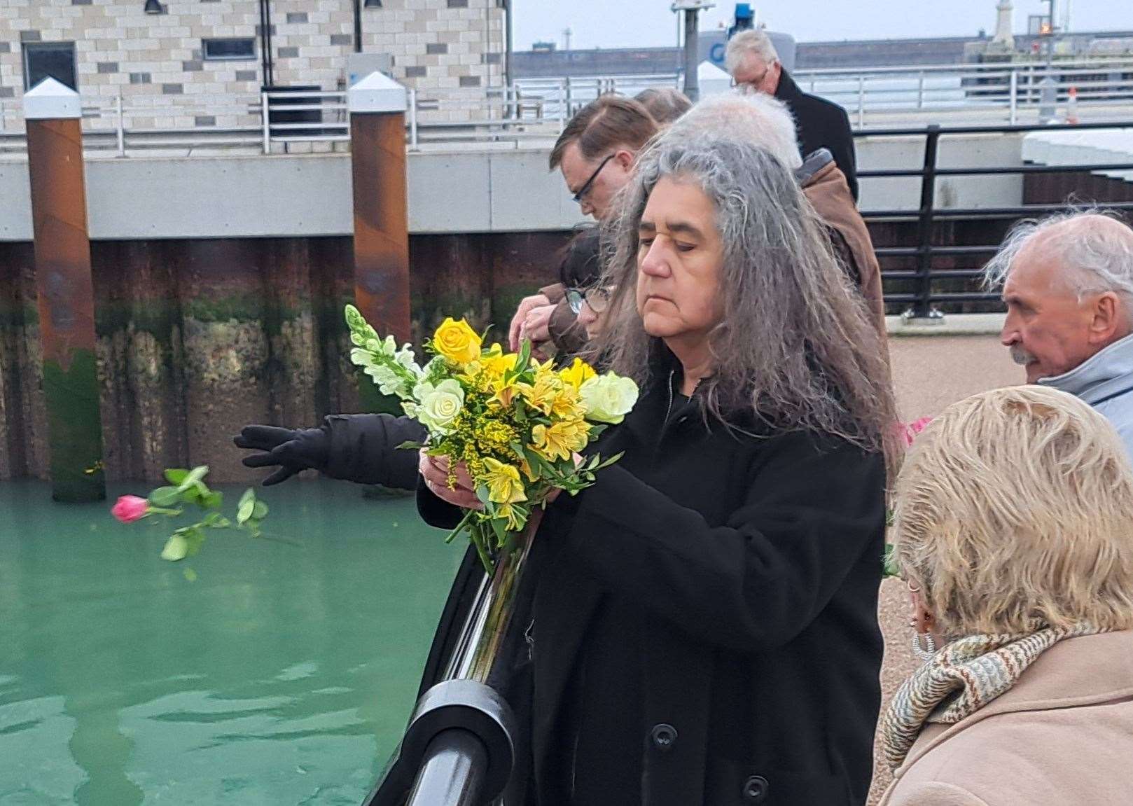 Former Herald crew member Rebecca Sawbridge casts flowers from Marina pier