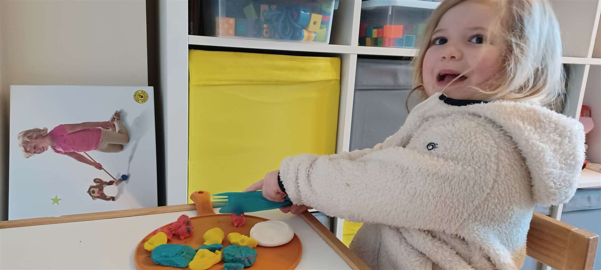 Learning how to cut food with the help of a plate of Playdoh