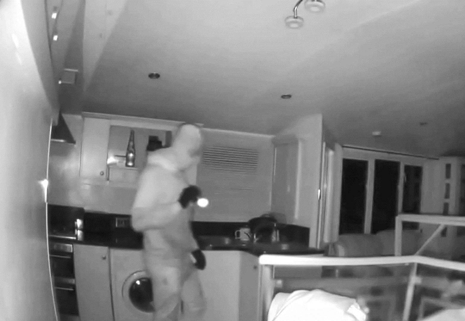 Masked burglar creeps around the kitchen of a mobile home at Bonnington Farm in Aldington, near Ashford