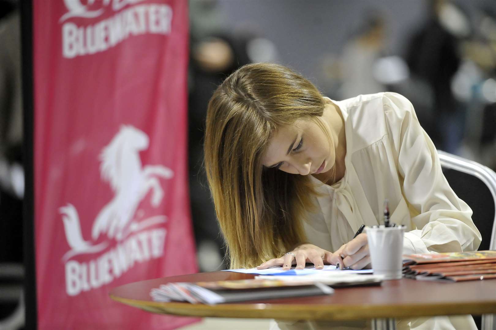 An applicant fills out a form at the jobs fair in Bluewater