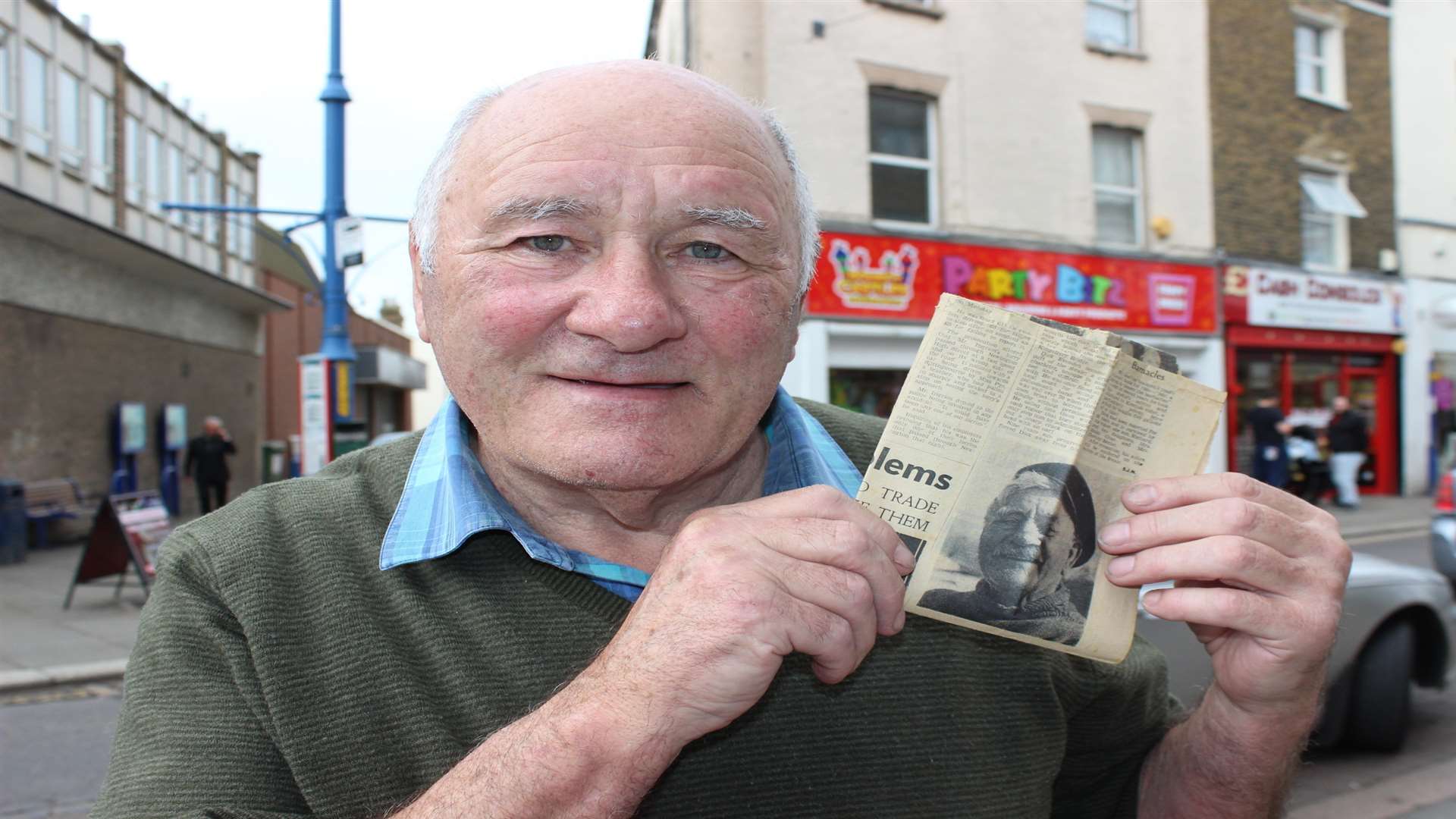 John Cross holding up a picture of his grandfather