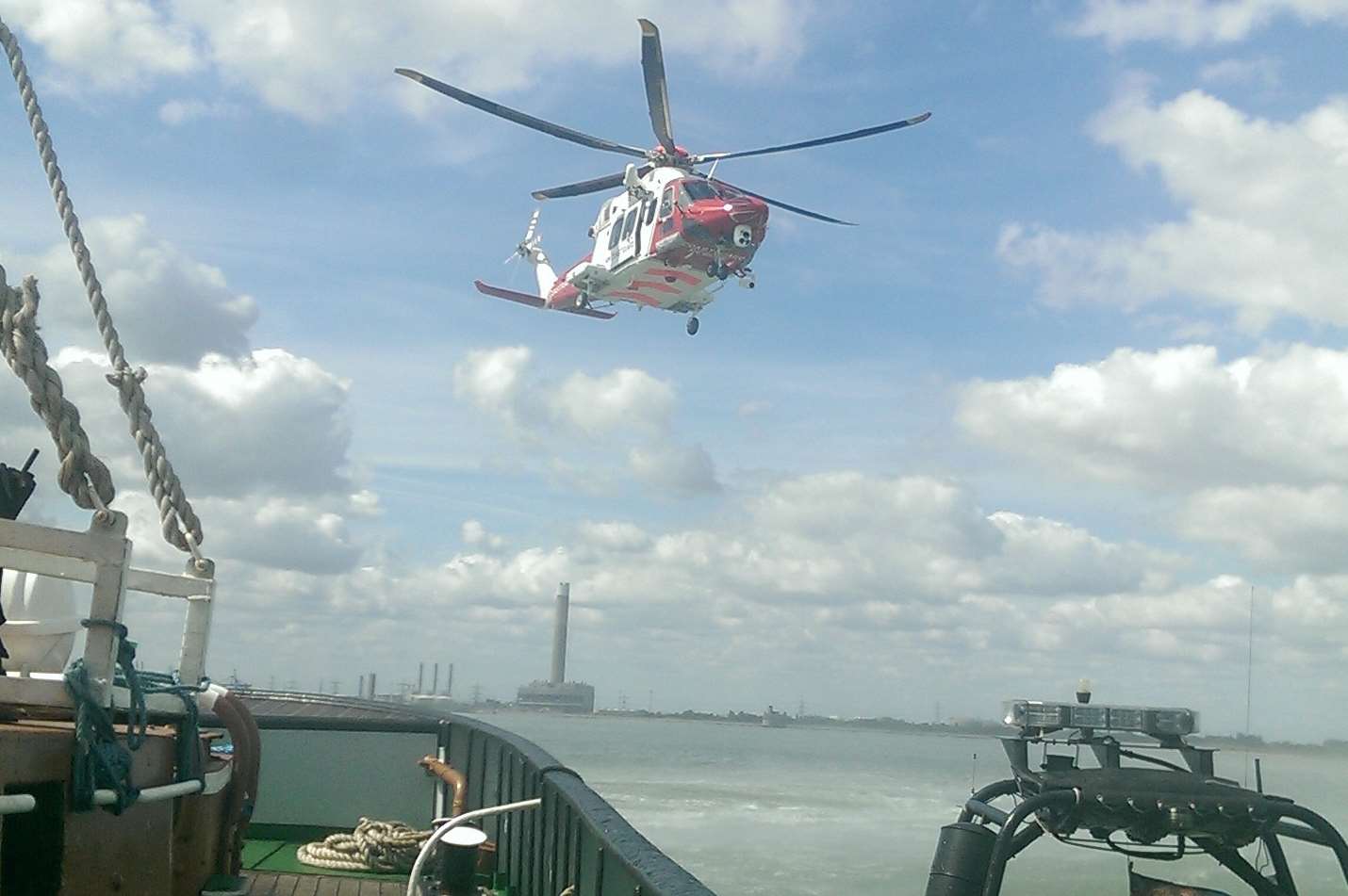 The coastguard helicopter hovers over the tug