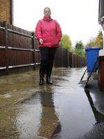 Mandy Beeton with the flooded sewerage drain outside her home in Minster