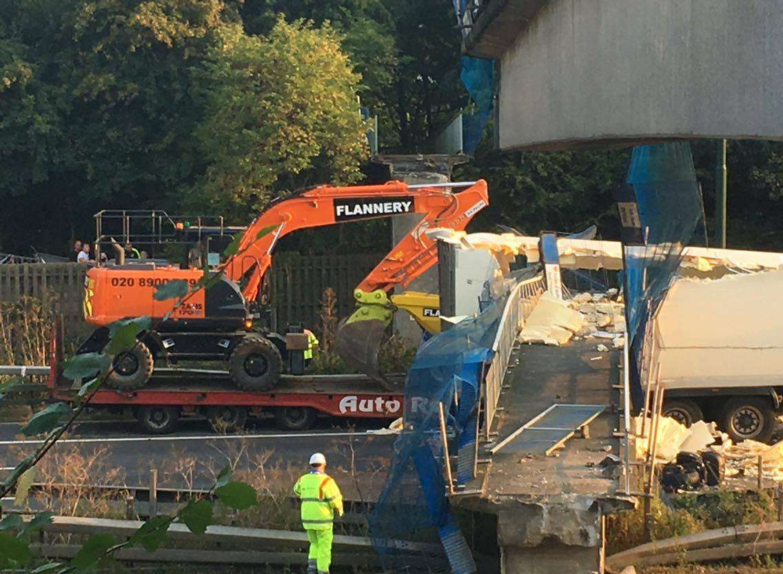 Workers at the scene of the M20 bridge collapse. Picture: Marcus Marchant