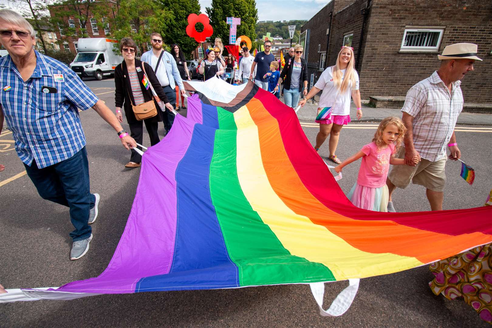 Pride-goers holding the LGBTQ+ progress flag. Photo: Dover Pride/David Goodson Photography