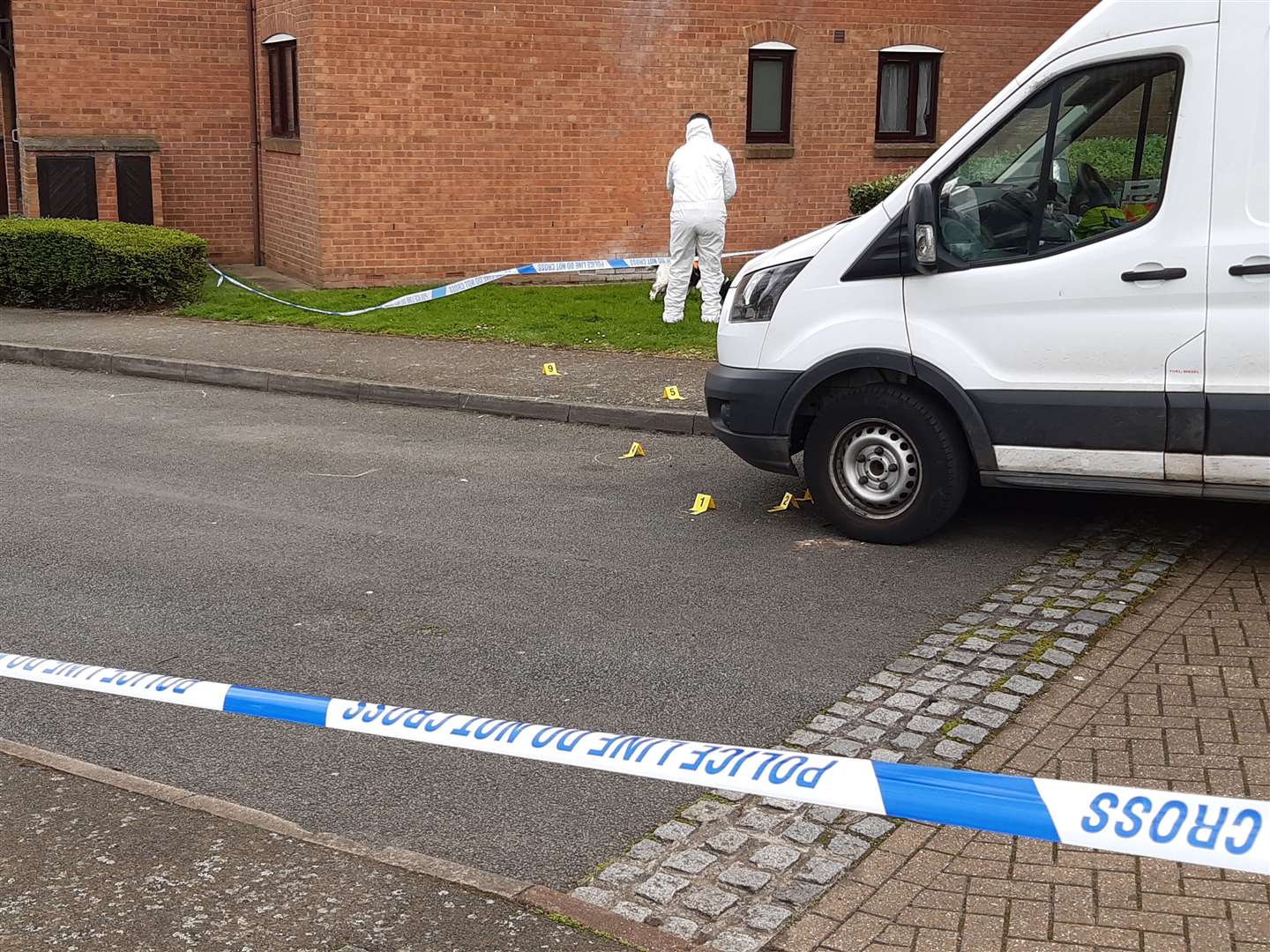 Police evidence markers on the road, after a shooting in Cooper Close, Greenhithe.