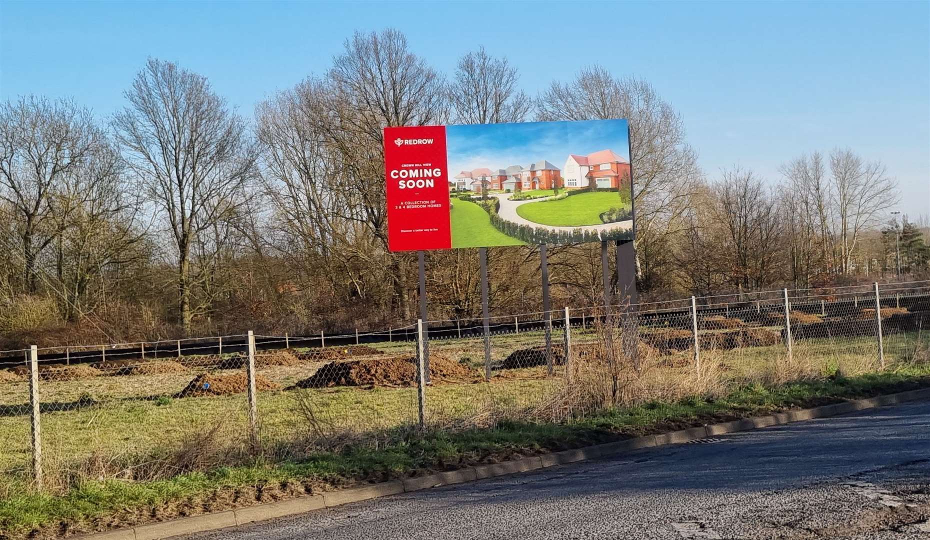A sign advertising the scheme has been erected by the roadside; Redrow is promoting the development as 'Crown Hill View'