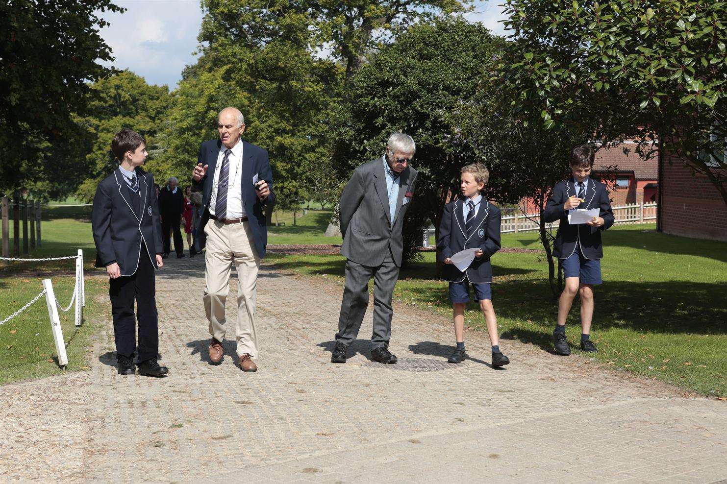 From left, Bruce Cripps and Dr Alexander Robinson get shown around by some current pupils