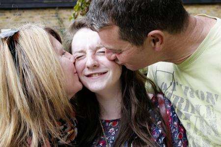 GCSE student Shannon Sutton gets big kisses from her proud parents after picking up her results at Rainham School for Girls