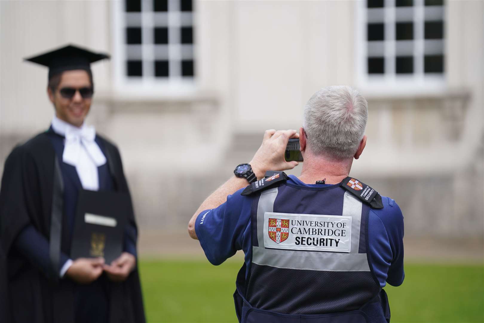 Security officers allowed new graduates into the yard at Senate House for photographs after the protesters left (Joe Giddens/ PA)