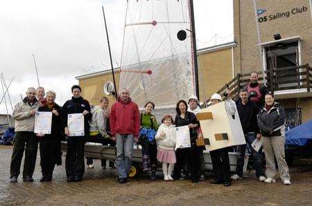 Members of the club outside the clubhouse with Tim Bell, also a club member, dressed as a giant plug to 'plug' the need for islanaders to vote.