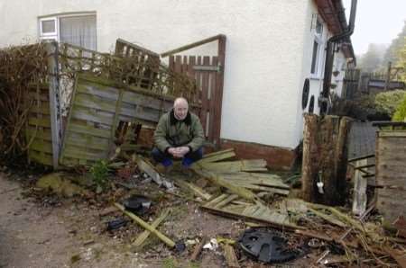 Trevor Elvy surveys the damage to his and neighbour's property