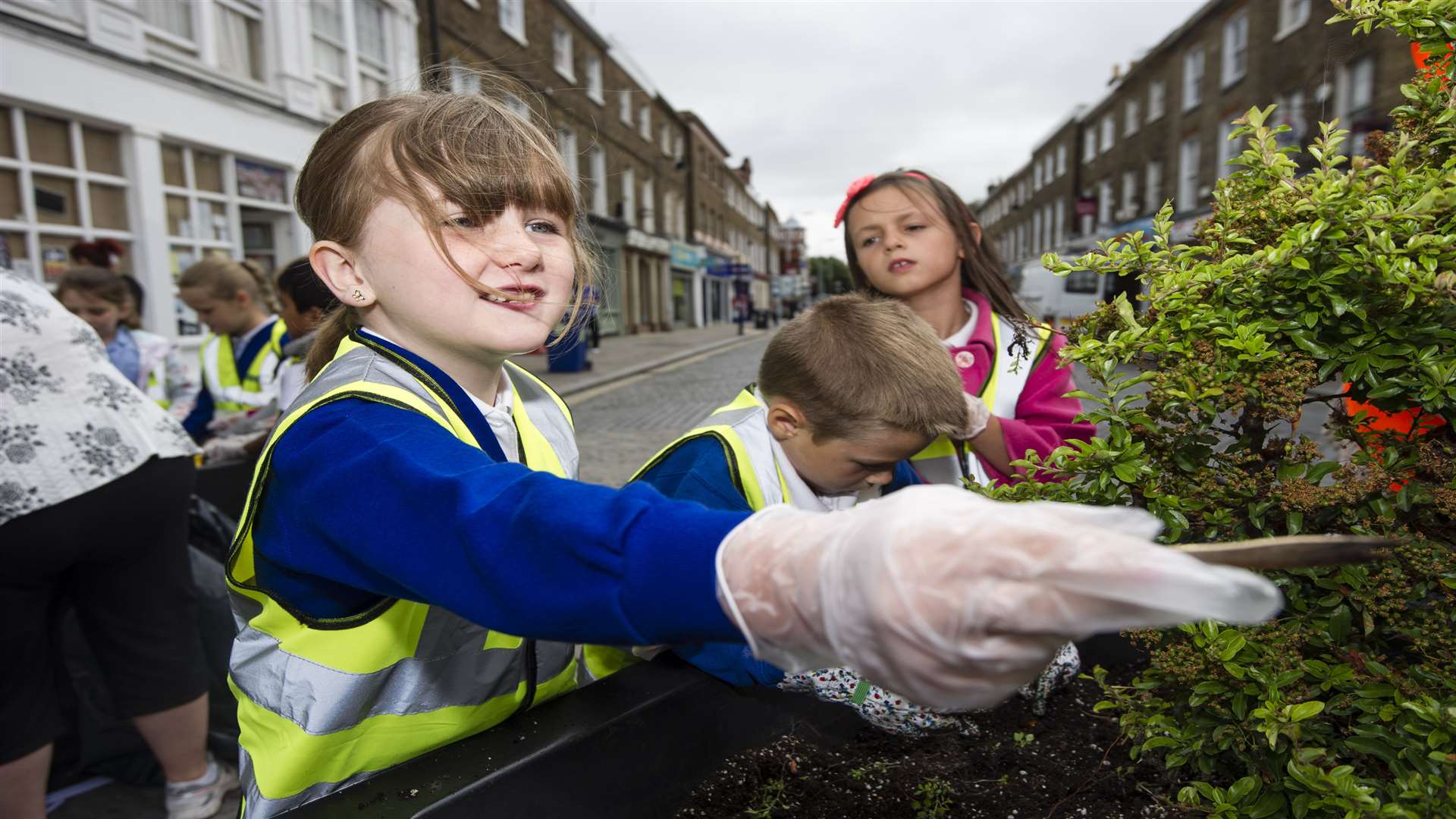 Youngsters planting flowers in the planters around the clock tower and Broadway, Sheerness