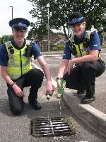 Best place for it - PCSOs Sean Smith and Hayley Aldridge pour the confiscated booze away