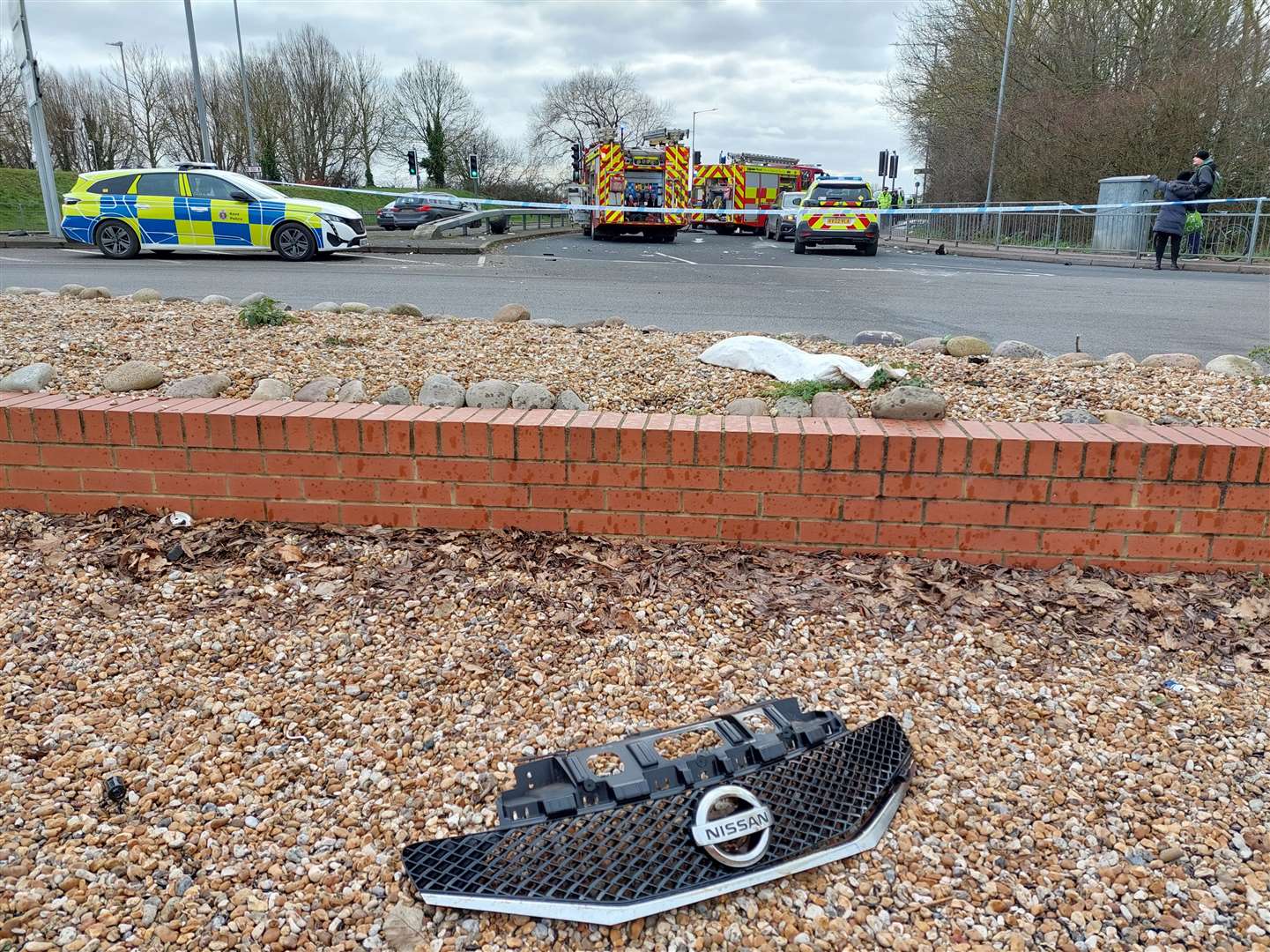 Debris from the grey Nissan is on the nearby roundabout